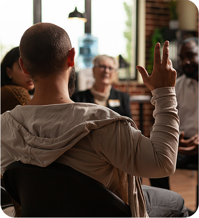Man raising hand in group therapy session