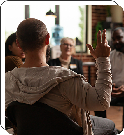 man raising hand in group therapy sesssion